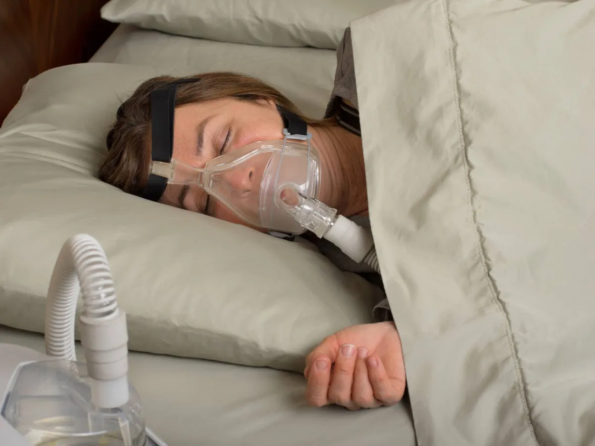 Patient asleep wearing a CPAP mask