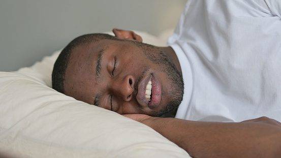 Young African Man Snoring in Bed, Sleeping